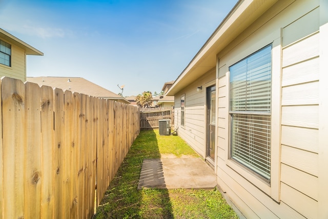 view of yard featuring central air condition unit and fence