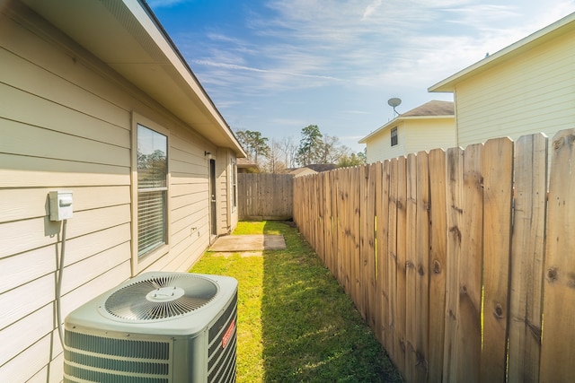 view of yard with central air condition unit and fence