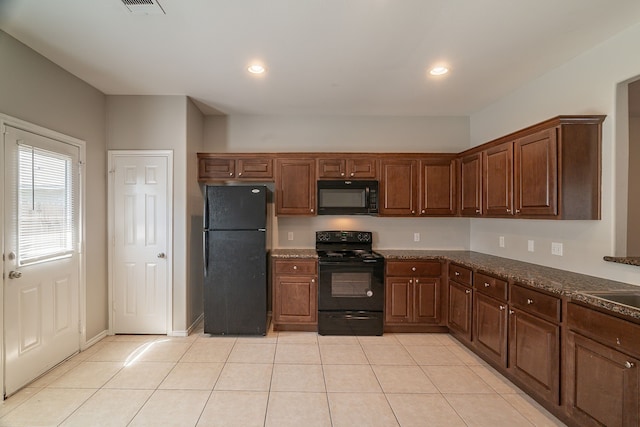 kitchen featuring light tile patterned floors, dark stone counters, black appliances, and recessed lighting