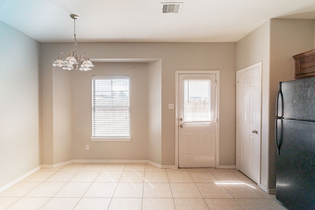 interior space featuring light tile patterned floors, baseboards, visible vents, and a chandelier