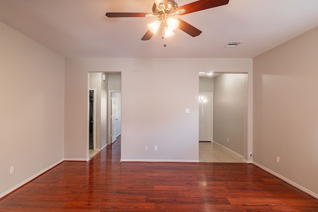 empty room featuring visible vents, baseboards, ceiling fan, and wood finished floors