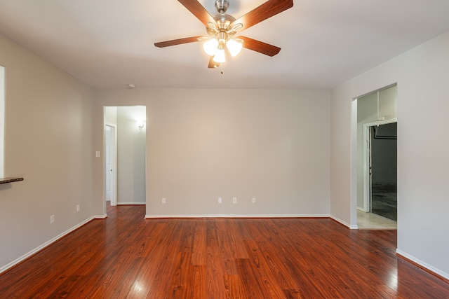 spare room with baseboards, wood-type flooring, and a ceiling fan