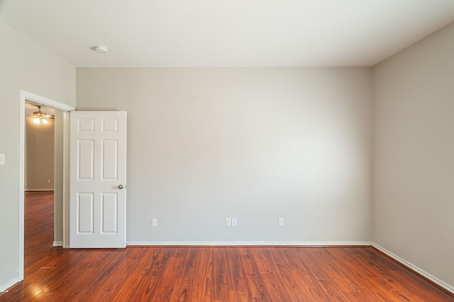 empty room with baseboards, wood finished floors, and a ceiling fan