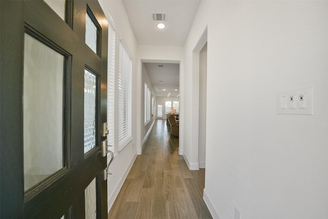 corridor featuring recessed lighting, wood finished floors, visible vents, and baseboards