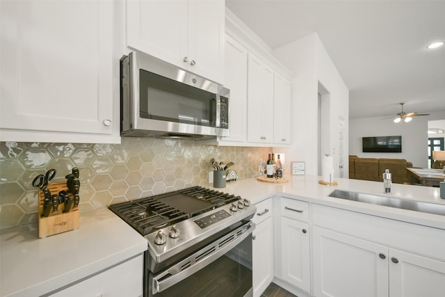 kitchen featuring decorative backsplash, light countertops, white cabinets, and stainless steel appliances