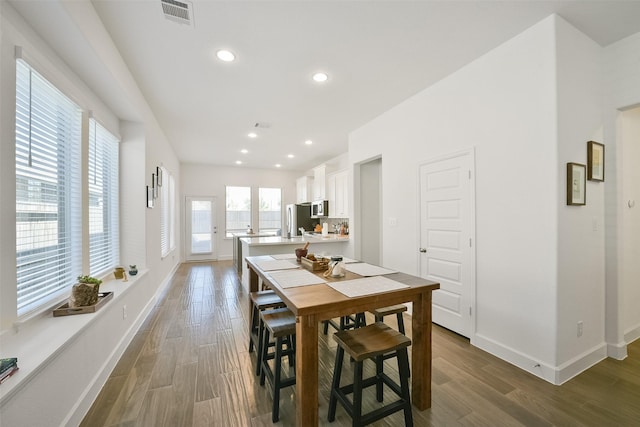 dining room featuring visible vents, baseboards, and wood finished floors