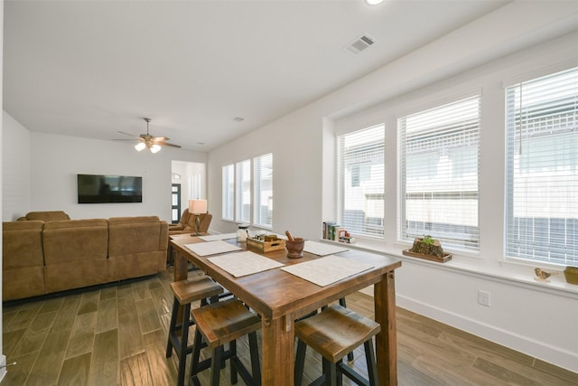 dining space with visible vents, ceiling fan, baseboards, and wood finished floors