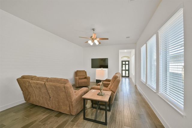 living room featuring a ceiling fan, baseboards, and wood finished floors