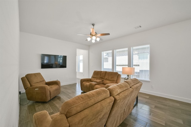 living room with wood finished floors, visible vents, and baseboards