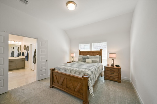 bedroom with visible vents, baseboards, connected bathroom, lofted ceiling, and light colored carpet