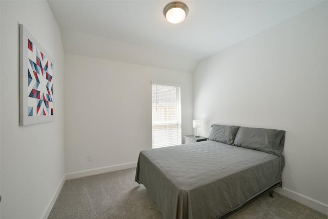 carpeted bedroom with baseboards and vaulted ceiling