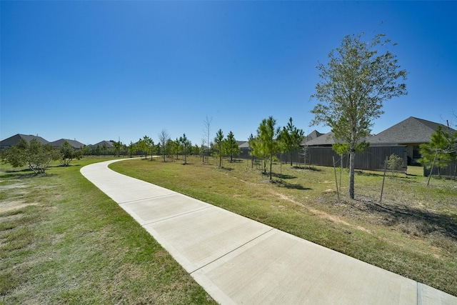 view of home's community featuring a lawn and fence