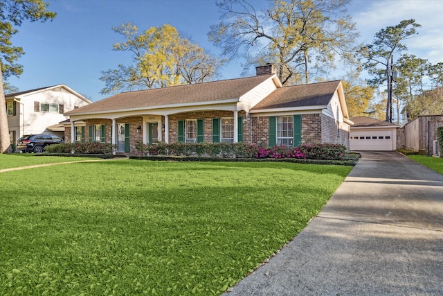 view of front of property with a chimney, a front lawn, an outdoor structure, a detached garage, and brick siding