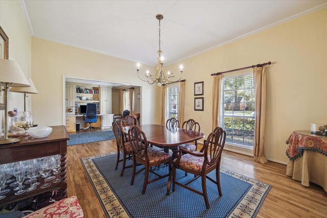 dining area featuring baseboards, light wood-type flooring, an inviting chandelier, and ornamental molding