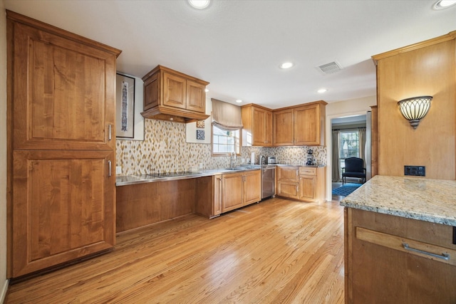 kitchen with visible vents, light wood finished floors, stainless steel dishwasher, black electric cooktop, and backsplash