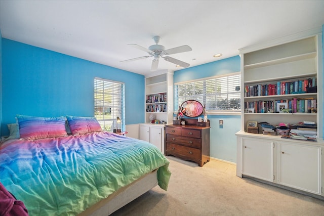 bedroom with a ceiling fan and light carpet