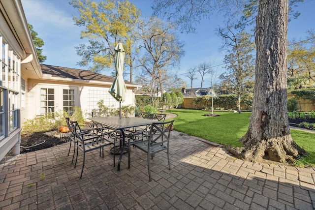 view of patio with french doors, outdoor dining space, and fence