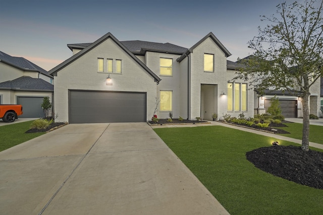 view of front of home with brick siding, an attached garage, concrete driveway, and a front yard