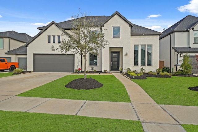 view of front facade with driveway, roof with shingles, a front lawn, a garage, and brick siding