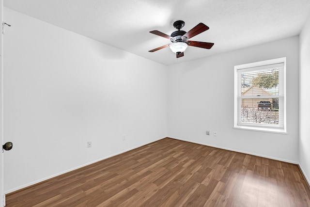 unfurnished room featuring a ceiling fan, baseboards, and wood finished floors