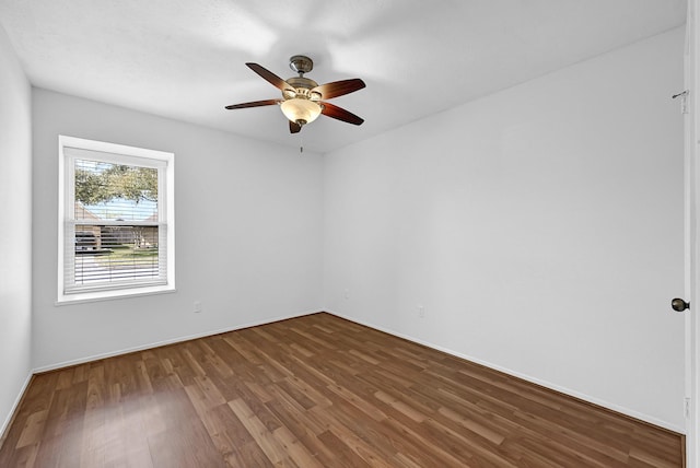 spare room with baseboards, a ceiling fan, and wood finished floors