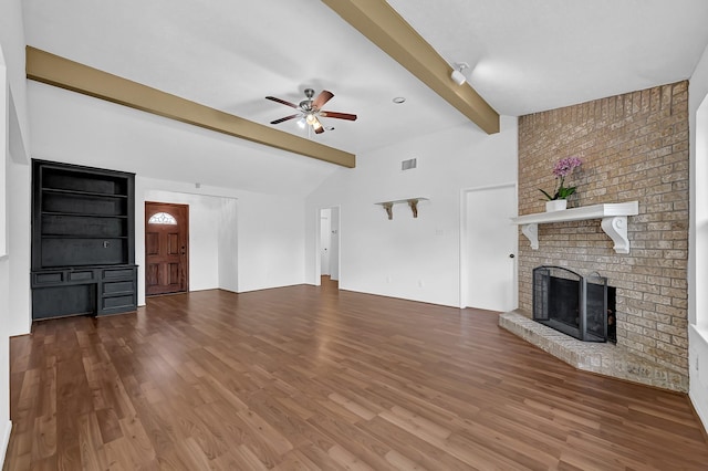 unfurnished living room with visible vents, a ceiling fan, wood finished floors, a fireplace, and vaulted ceiling with beams