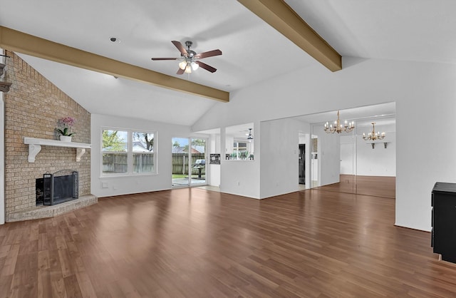 unfurnished living room featuring ceiling fan with notable chandelier, wood finished floors, vaulted ceiling with beams, and a fireplace