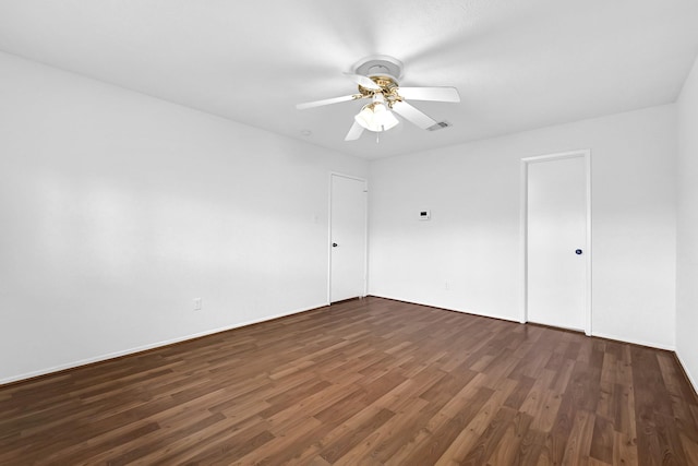 unfurnished room featuring a ceiling fan, dark wood-style floors, and visible vents