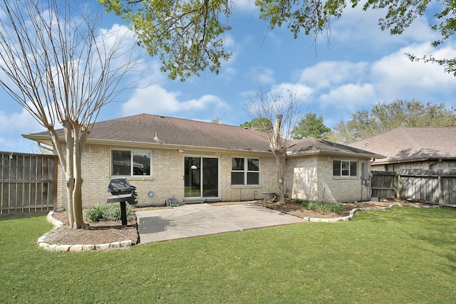 rear view of property with a patio, brick siding, and a fenced backyard