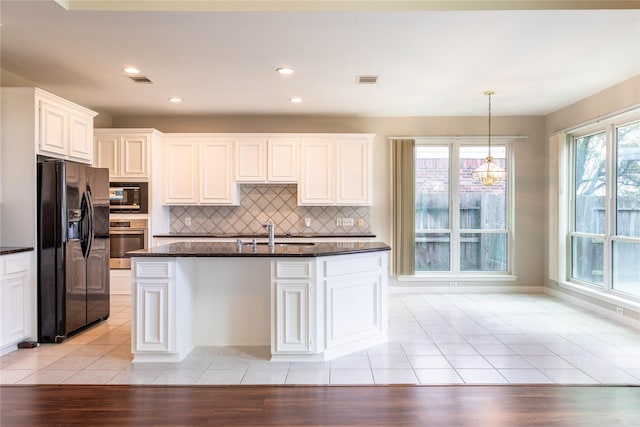 kitchen with light tile patterned floors, decorative backsplash, black appliances, and a sink