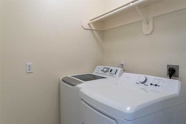 clothes washing area featuring laundry area and washer and clothes dryer