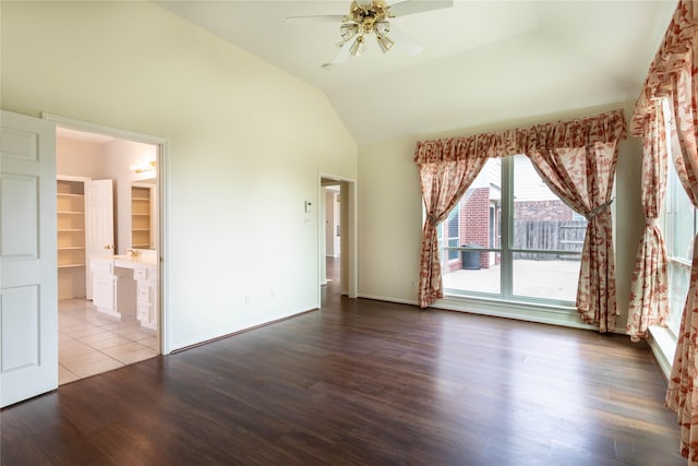 interior space featuring a ceiling fan, lofted ceiling, wood finished floors, and baseboards