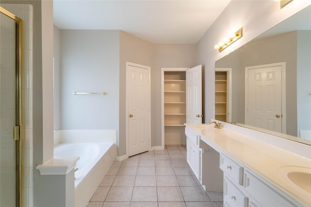 bathroom featuring tile patterned floors, a walk in closet, double vanity, a stall shower, and a bath