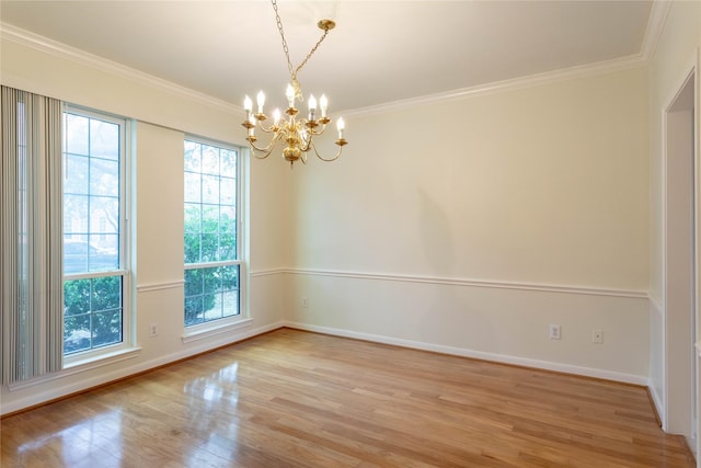 empty room featuring a notable chandelier, crown molding, light wood-type flooring, and baseboards