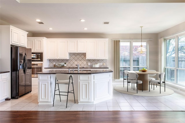 kitchen with light tile patterned floors, white cabinets, black appliances, and a sink