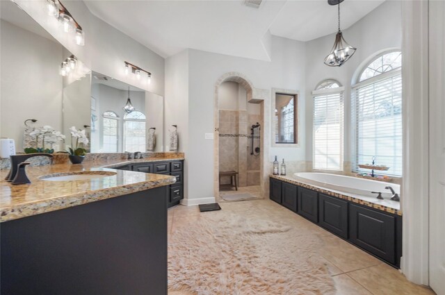 full bathroom featuring vanity, tiled shower, tile patterned flooring, a garden tub, and a chandelier