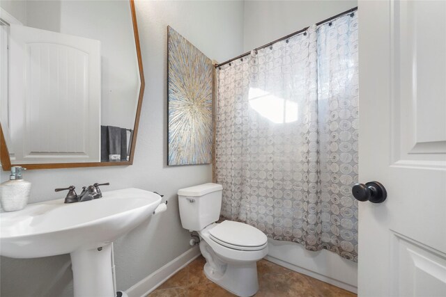 full bath featuring tile patterned floors, toilet, a sink, shower / bath combination with curtain, and baseboards