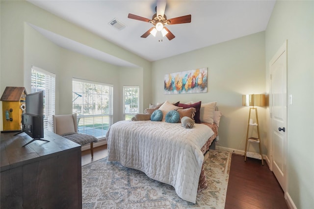 bedroom with visible vents, a ceiling fan, baseboards, and wood finished floors