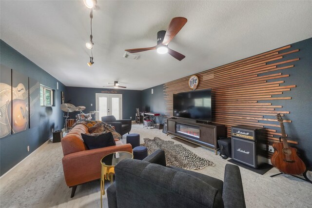 living room with visible vents, french doors, carpet, ceiling fan, and an accent wall