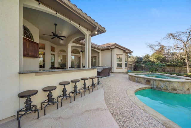 view of swimming pool featuring a ceiling fan, fence, a fenced in pool, an in ground hot tub, and a patio area