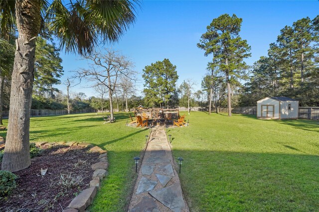 view of yard with an outdoor structure, a storage unit, and fence