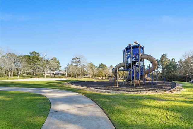 view of property's community featuring a lawn and playground community