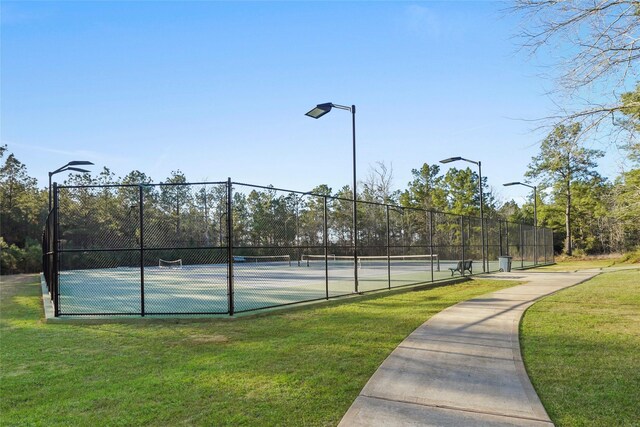 view of sport court featuring a yard and fence