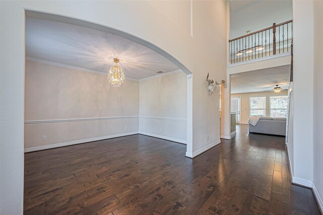10018 Durango Path Ln, Cypress, TX 77433 - unfurnished room featuring arched walkways, crown molding, and dark wood-style flooring