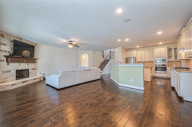 10018 Durango Path Ln, Cypress, TX 77433 - living area with a ceiling fan, dark wood finished floors, a fireplace, recessed lighting, and stairs