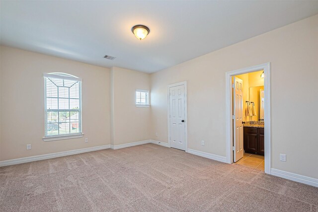 10018 Durango Path Ln, Cypress, TX 77433 - unfurnished bedroom featuring visible vents, light colored carpet, ensuite bath, and baseboards