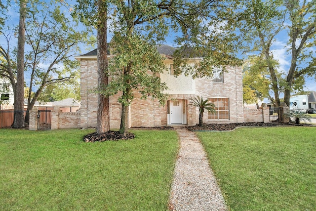 view of front of property with a front lawn, fence, and brick siding