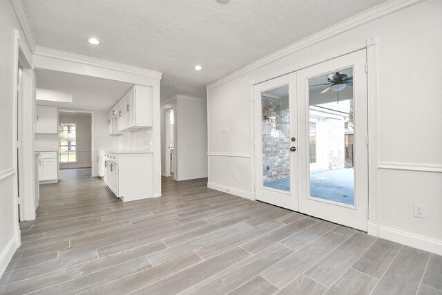 kitchen with wood finish floors, french doors, white cabinets, and crown molding