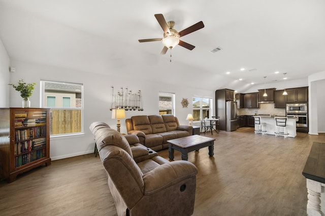 living area with visible vents, plenty of natural light, a ceiling fan, and wood finished floors