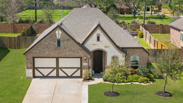 view of front of home featuring a front lawn, fence, brick siding, and driveway